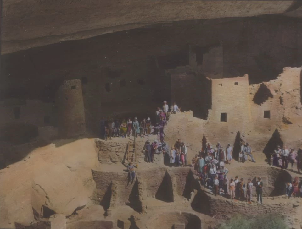 Black and white photo of people standing on stone ruins.