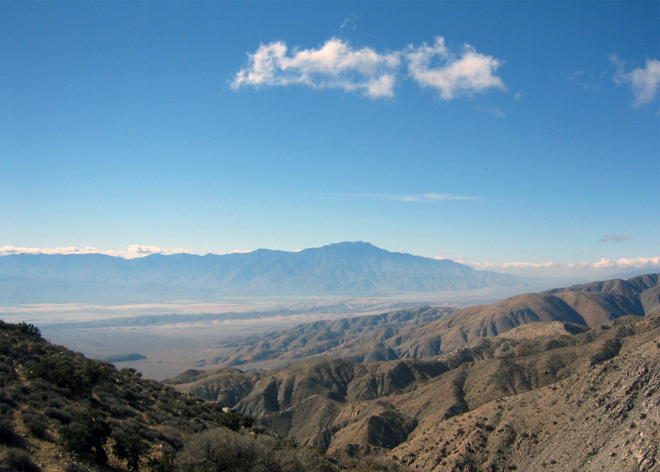 A clear view of a valley and mountains with bright blue skies