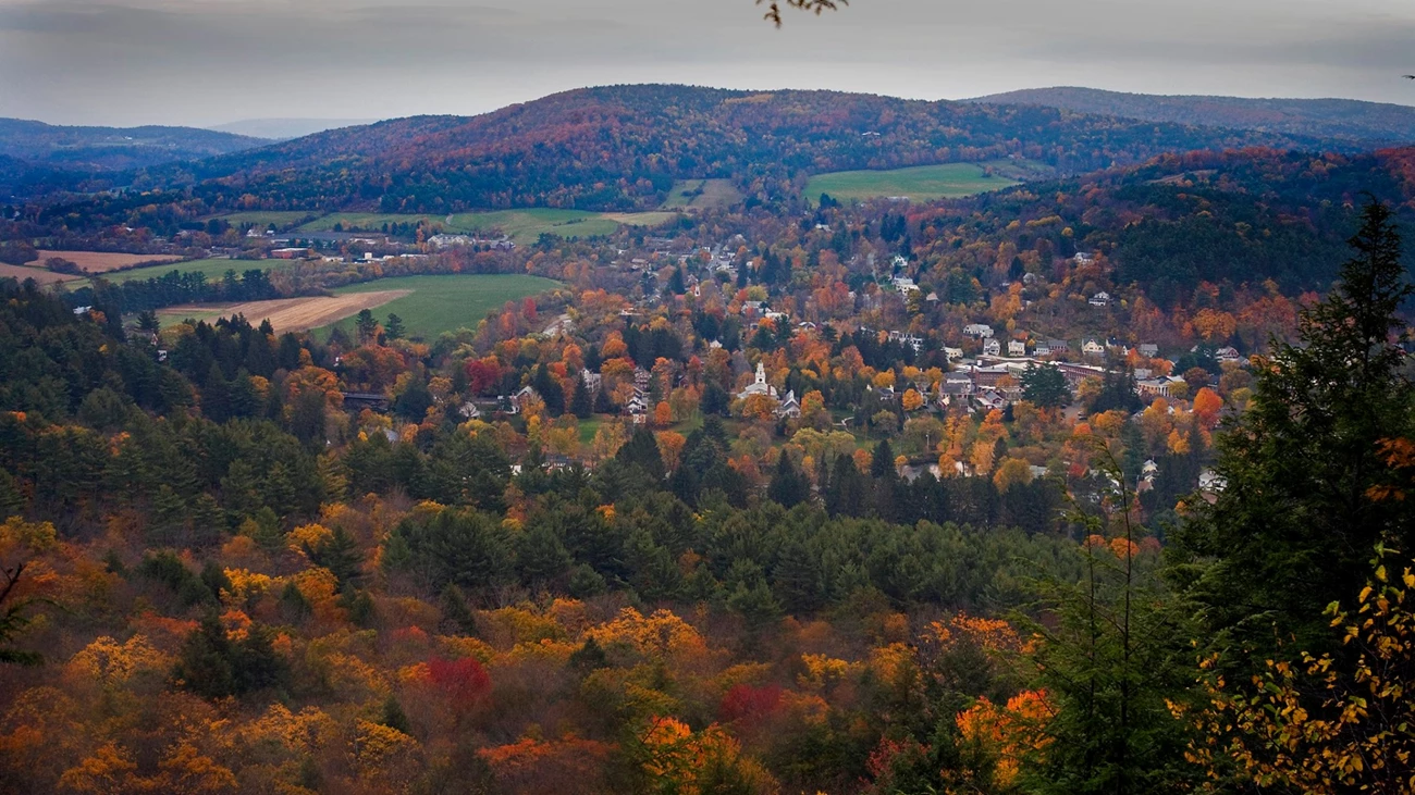 a black and white photo of a town in a valley with very few trees