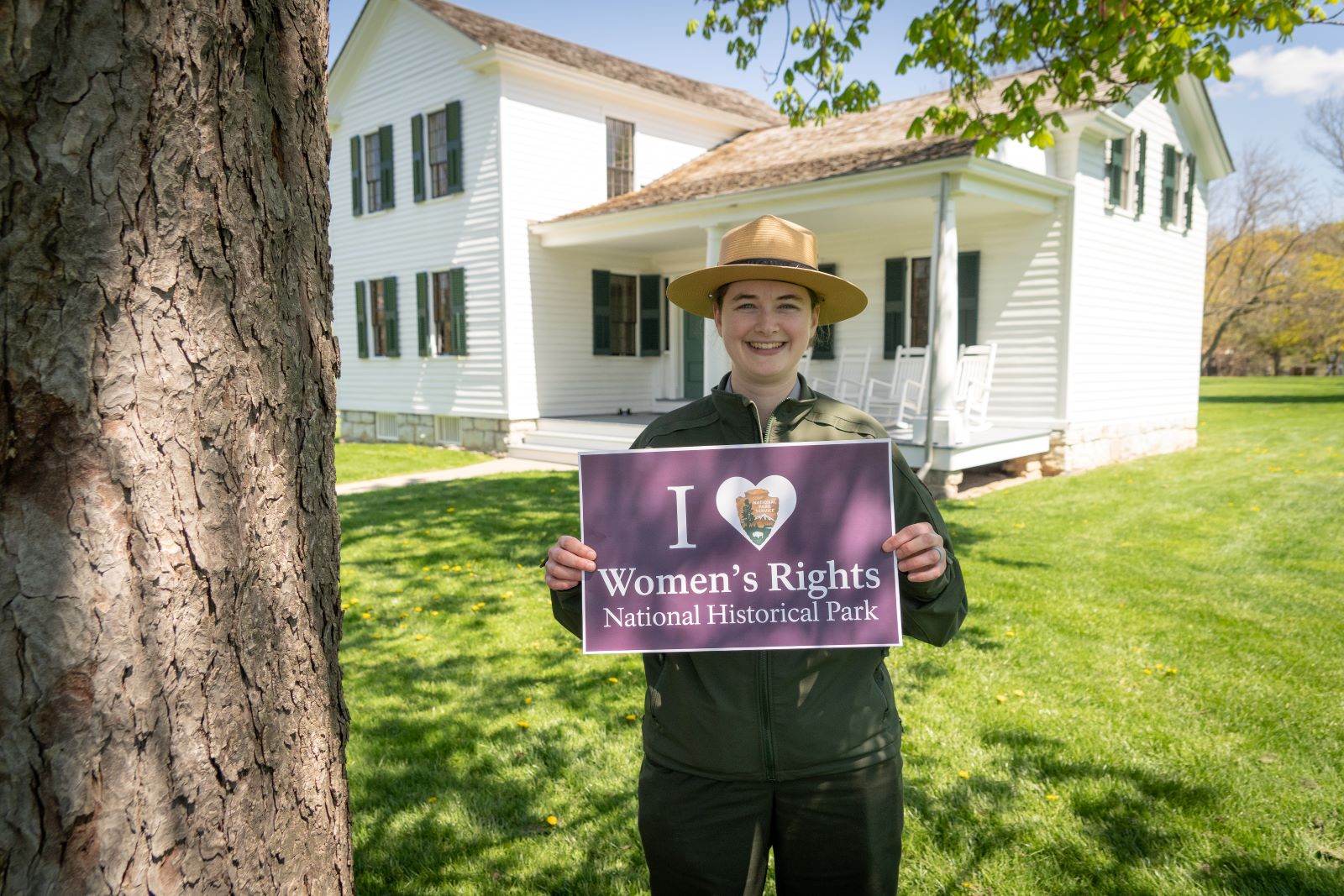 A ranger holding a sign that reads A ranger holding a sign that reads