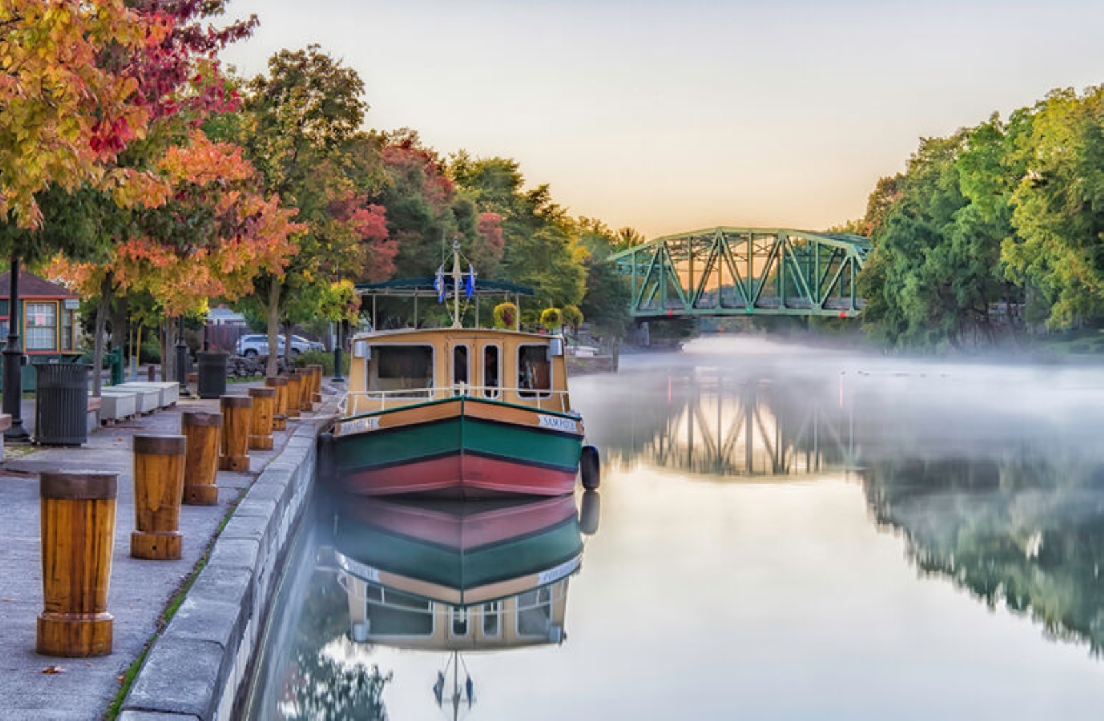 A canal boat on the water with mist and fall trees A canal boat on the water with mist and fall trees