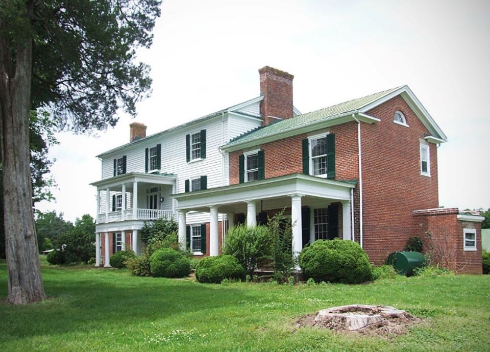 Image of Hyde Park's main house. The structure is a mix of Greek Revival and Federal style architecture. The earliest part of the house is brick, with white wood-paneled additions visible in the picture.