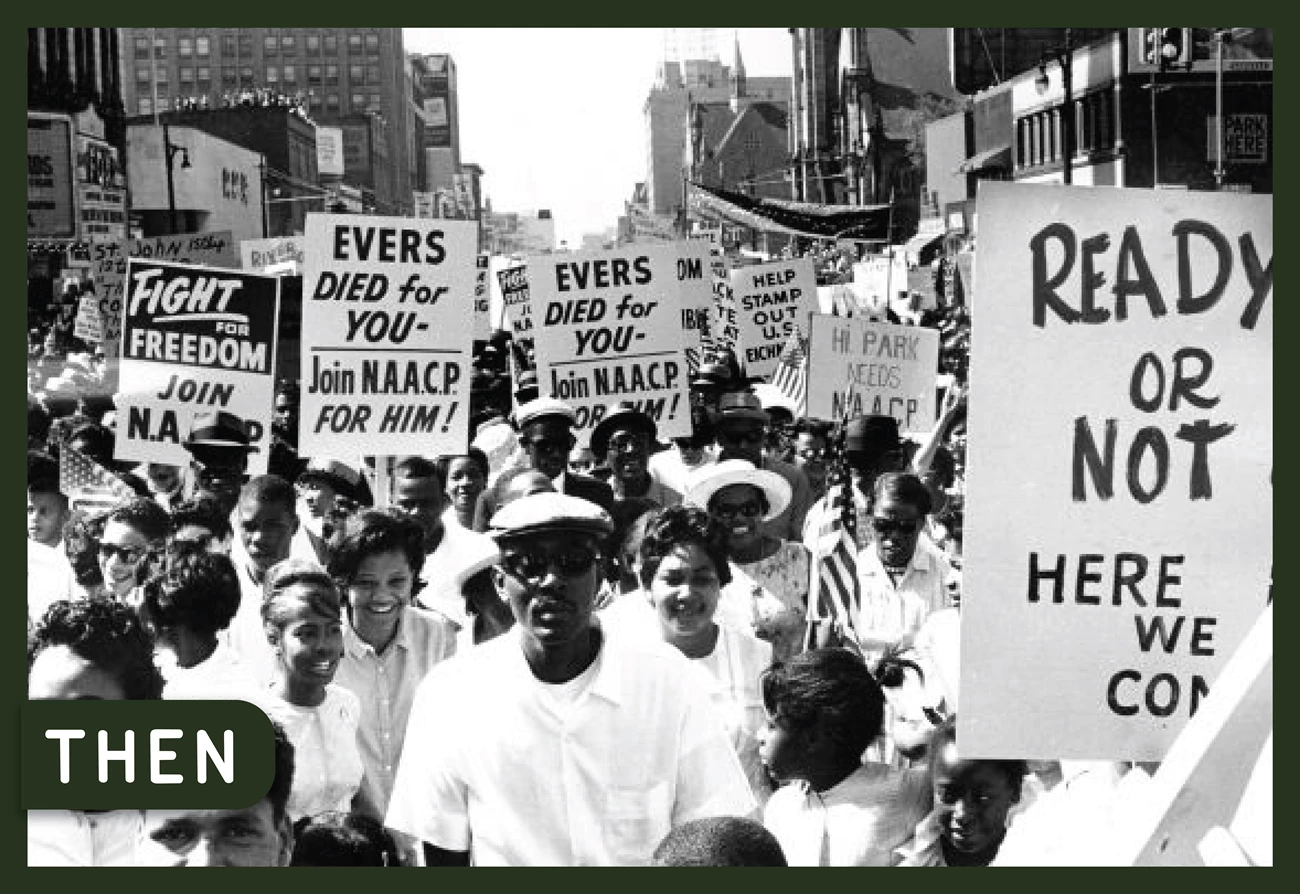 A diverse crowd of people carrying signs with protest slogans, marching in the Detroit March to Freedom civil rights demonstration in 1963.