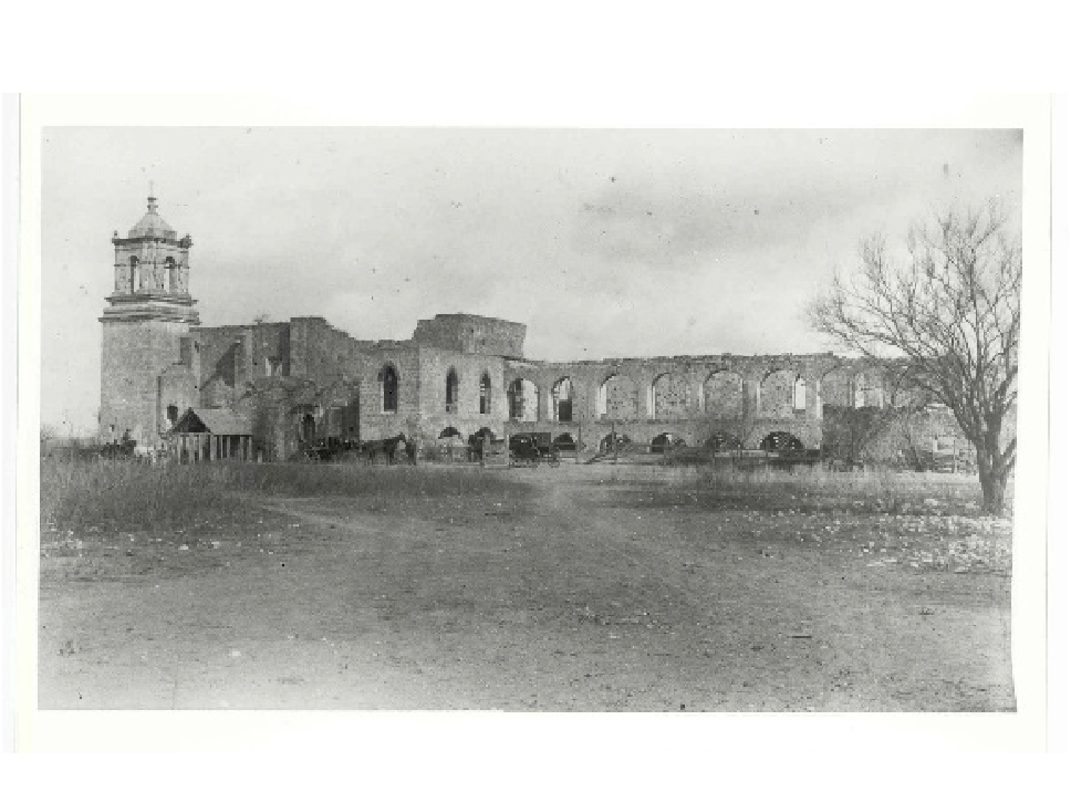 black and white photo of a stone church arches with trees around