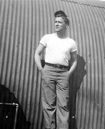 black and white photo of a man leaning against a metal background