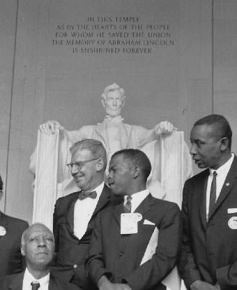 B&amp;W photo of men in suits standing in front of lincoln statue