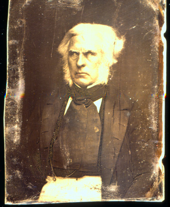 Photograph of Dr. John McLoughlin wearing a dark-colored suit and cravat.