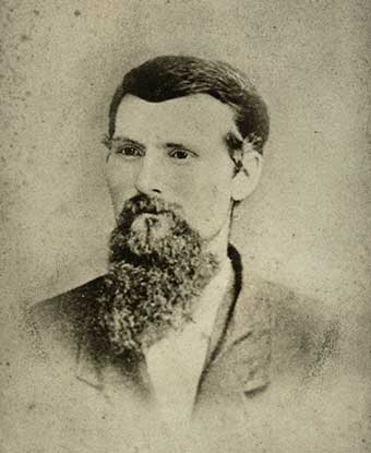 An 1879 portrait photo depicts a bearded man in a suit jacket. An 1879 portrait photo depicts a bearded man in a suit jacket.