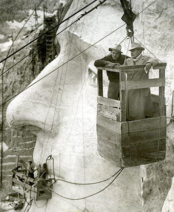 Gutzon Borglum (right) and Lincoln Borglum observe work on Mount Rushmore from the tram car. Gutzon Borglum (right) and Lincoln Borglum observe work on Mount Rushmore from the tram car.