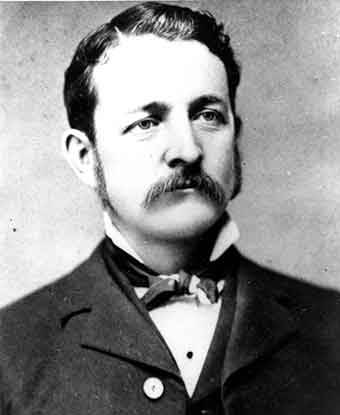An 1883 portrait photo depicts a man with a mustache and sideburns in a suit with a bow tie. An 1883 portrait photo depicts a man with a mustache and sideburns in a suit with a bow tie.