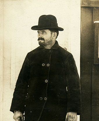 A 1904 photograph shows a rugged man outdoors in a hat and winter coat. A 1904 photograph shows a rugged man outdoors in a hat and winter coat.