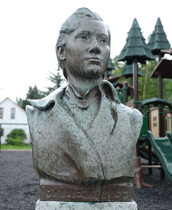 Metal bust of a woman's head and soldiers.
