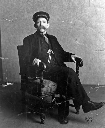 A portrait of a man seated in a chair.