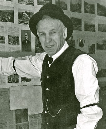 A man in a vest, white shirt, and hat.