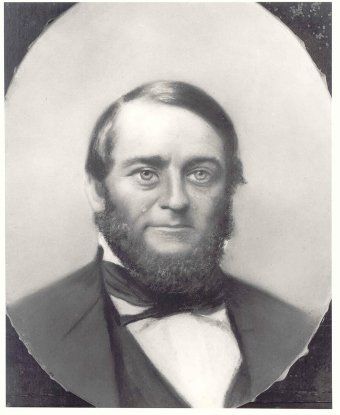 black and white portrait photograph of a middle aged white man with a full beard wearing a suit