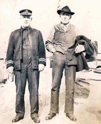 A boat captain and Franklin Lowell stand beside each other on a dock, in this 1912 photo. 