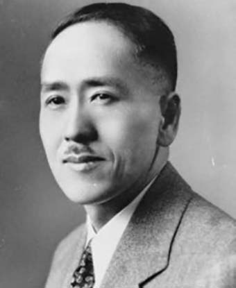 A black and white photo of Harry Kawabe wearing a suit. 