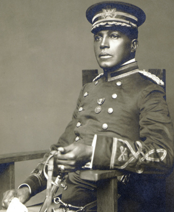 A military officer in a full dress uniform and hat