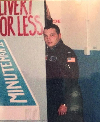 A uniformed officer stands against a painted blast door.