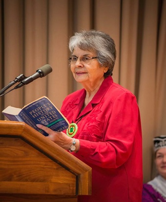 woman reading at a podium