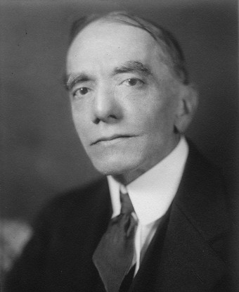 A man wearing a dark suit and tie.