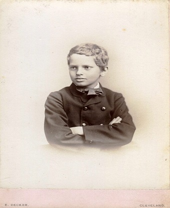 a black and white photo showing a young man with his arms crossed in front of him