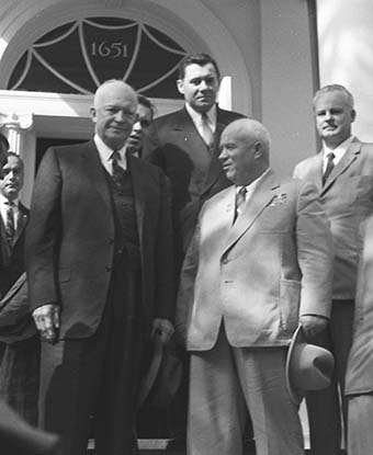 a group of men in suits standing outside a doorway