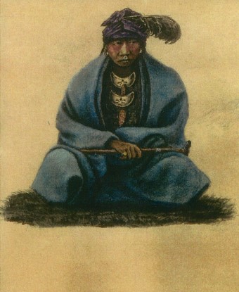 A seated American Indian wearing a blue blanket and holding a pipe
