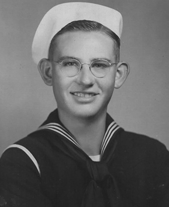 Black and white photograph portrait of a man in sailor&#39;s dress blues with a white cap.