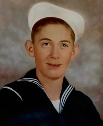 Color photograph portrait of a man in sailor's dress blues with a white cap.