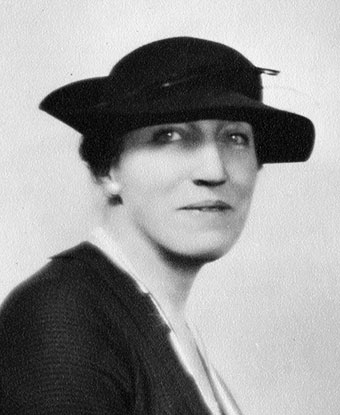 Head and shoulder portrait of a woman wearing a brimmed hat.