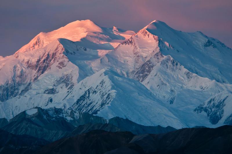 vast snowy mountain tinged pink on one side