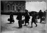Immigrants with their luggage walk to Ellis Island