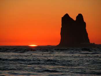 A sliver of sun over the ocean at sunset.