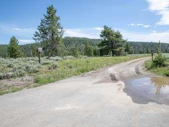 A small wooden sign reads "Bighorn" on the left side of a road.