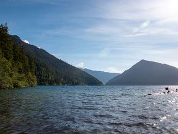 A glittering lake with green hills on all sides.