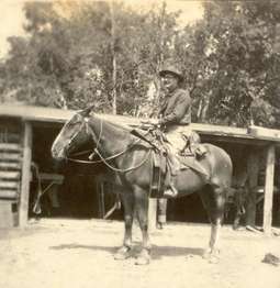 A gentleman sits on horseback in front of the saddle room at the Bar BC.
