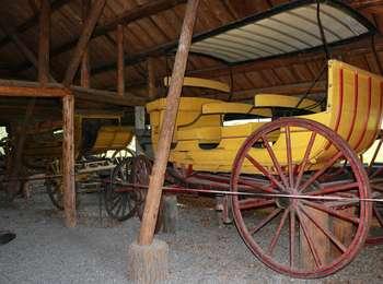 Yellow JY Dude Ranch wagon with red wheels inside the Transportation Barn