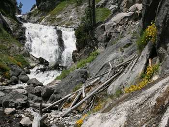 A waterfall cascades over a rock-strewn cliff.
