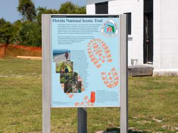 A metal framed National Park Service sign with the title text,