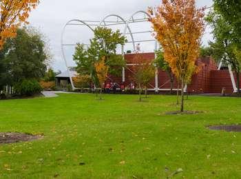 End of the Oregon Trail Center is a series of large, red, rectangular buildings with tall, white, metal hoops above them, resembling a wagon train