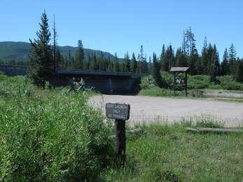 Flagg Ranch gravel boat launch on the Snake River with the highway bridge above.