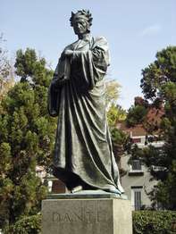 A bronze standing figure of Dante, renowned poet, shows him in the gown of a scholar and crowned with a laurel wreath, on a pedestal of sea-green granite. 