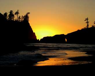 A beach and cliffs at sunset.