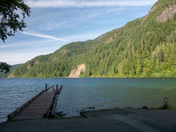 A boat ramp and a dock extending into a bright blue lake.
