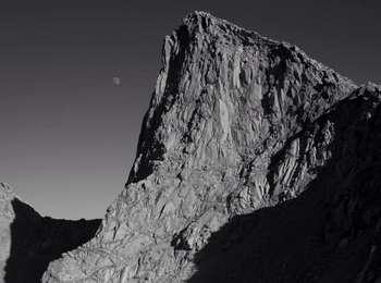 A black and white photo of a rocky peak