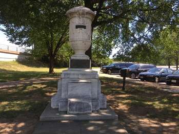 A white marble urn atop a stone pedestal