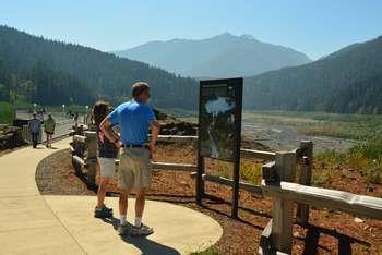 Visitors look at signs and views at an overlook.