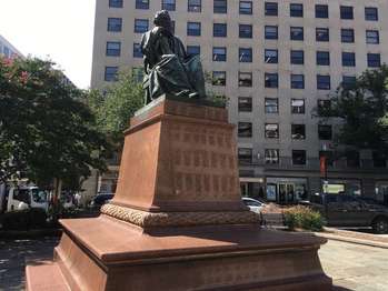A statue of Henry Wadsworth Longfellow sitting on a chair