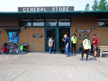 Group of bicycle riders standing outside the General Store at Colter Bay Village.